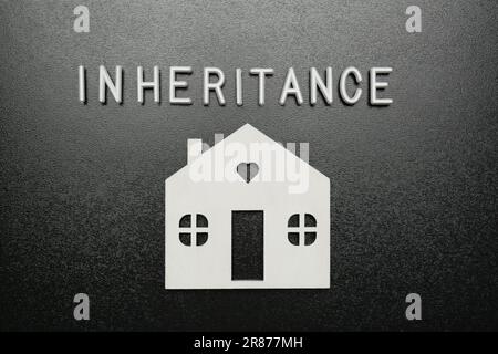 Worterbe mit weißen Buchstaben und Hausmodell auf schwarzem Hintergrund, flach liegend Stockfoto