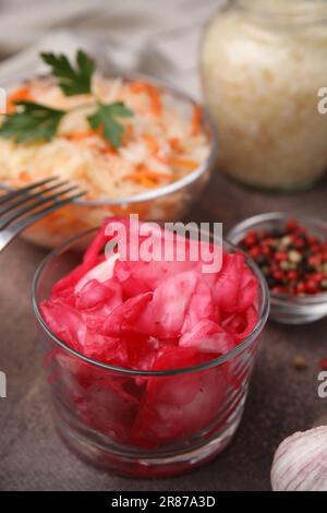 Köstliches Sauerkraut, nach verschiedenen Rezepten auf einem braunen Tisch zubereitet, Nahaufnahme Stockfoto