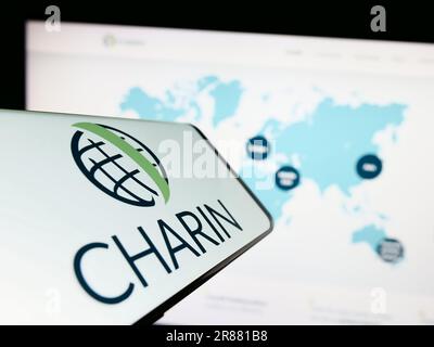 Smartphone mit Logo der globalen Charin e.V. auf dem Bildschirm vor der Website. Fokus auf die Mitte rechts des Telefondisplays. Stockfoto