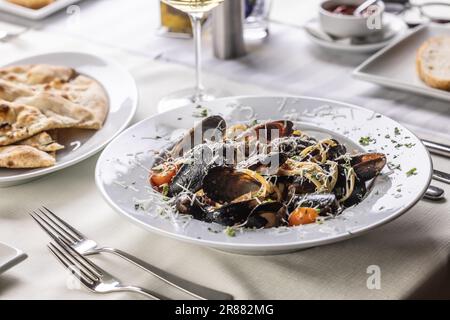 In einem Restaurant werden linguine Pasta mit Muscheln und geriebenem Pecorino serviert. Stockfoto