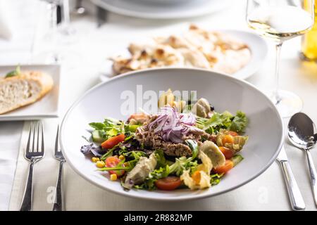 Gemischtes Gemüse, Mais, Kirschtomaten, Avocadosalat mit Thunfisch und rohen Zwiebeln. Stockfoto