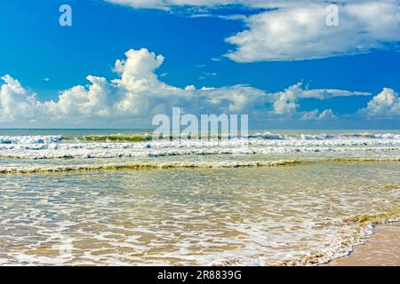 Wellen und Meeresschaum im farbenfrohen Meer an einem sonnigen Sommertag am Sargi Beach in Serra Grande, Südküste von Bahia Stockfoto