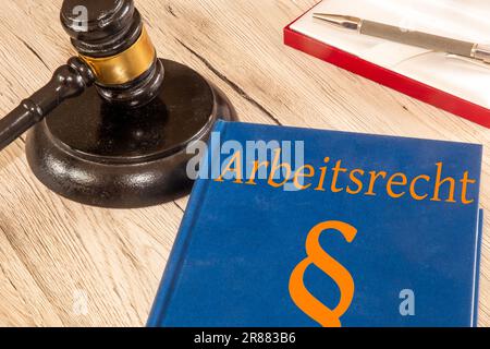 Symbolbild: Arbeitsrecht-Referenzbuch neben dem Hammer eines Richters Stockfoto