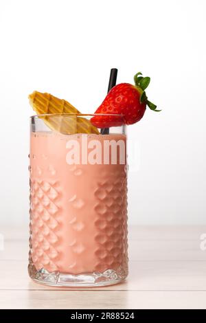 Nahaufnahme eines Erdbeermilchshake mit natürlichen Erdbeeren, Keksen und Stroh auf weißem Hintergrund und Kopierbereich Stockfoto
