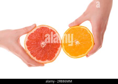 Weibliche Hände, die auf weißem Hintergrund geschnittene Portionen Orange und Grapefruit halten