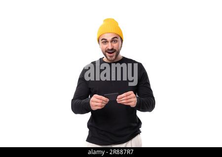 Ein kluger, authentischer männlicher, brünetter Erwachsener in einem schwarzen Pullover spricht auf weißem Hintergrund mit Kopierbereich über eine Idee Stockfoto