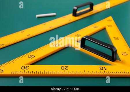 Dreieck, Lineal und Kreide auf grüner Tafel, Nahaufnahme Stockfoto