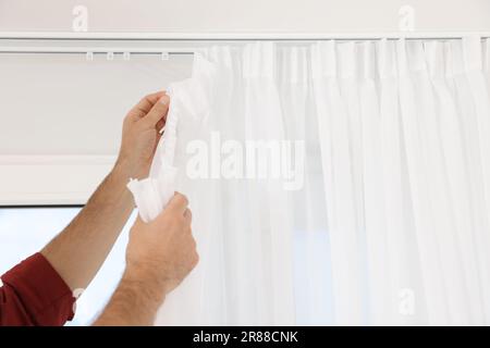 Arbeiter hängte Fenstervorhänge drinnen, Nahaufnahme Stockfoto