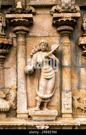 Reich geschnitzte Statue einer wunderschönen Frau mit Musikinstrument an der Wand des Tempels Venugopalaswamy im Sri Ranganathaswamy Vishnu Tempel Stockfoto