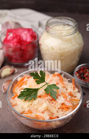 Köstliches Sauerkraut, nach verschiedenen Rezepten auf einem braunen Tisch zubereitet, Nahaufnahme Stockfoto
