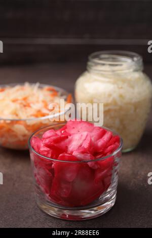 Köstliches Sauerkraut, nach verschiedenen Rezepten zubereitet, auf braunem Tisch, Nahaufnahme Stockfoto