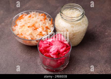Köstliches Sauerkraut nach verschiedenen Rezepten auf einem braunen Tisch zubereitet Stockfoto