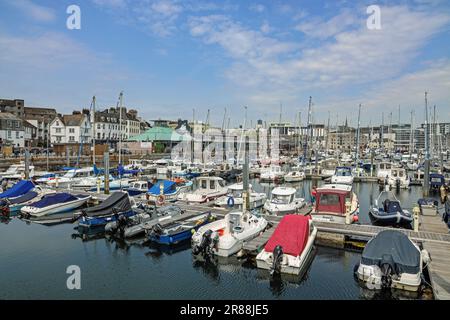 Blick über Sutton Harbour, Plymouth vom West Pier. Vollgestopft mit Freizeitbooten aller Größen. Geschäfte und Restaurants in der Ferne inklusive Stockfoto