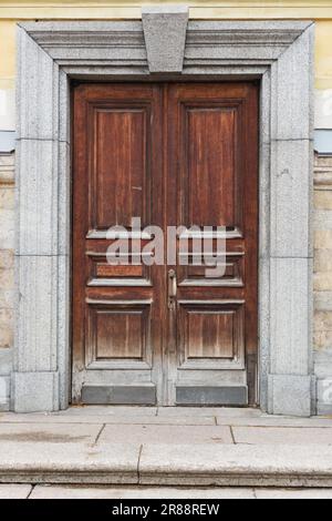 Geschlossene alte Holztür mit Granitdekor der Kathedrale im Gebiet der Peter-und-Paul-Festung, St. Petersburg, Russland Stockfoto