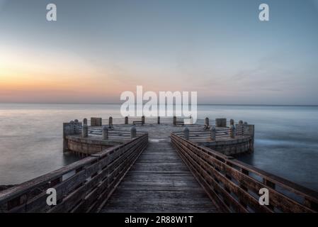 Am Morgen auf dem Pier und im Kreisverkehr mit Blick auf das Meer mit den herrlichen Farben des Sonnenaufgangs Stockfoto