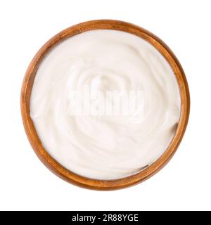 Frischjoghurt, in einer Holzschüssel. Gerührter Joghurt, auch Joghurts oder Joghurts, mit einem Fettgehalt von 10 %. Milchprodukt. Stockfoto