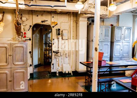 Innenansicht eines Raums mit einem hellroten Feuerhydranten und weißen Schränken an der Seitenwand Stockfoto