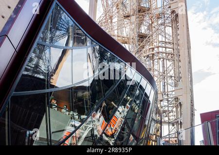 Ein atemberaubender Blick aus der Vogelperspektive auf ein modernes Gebäude mit großen Glasfenstern und dem berühmten Eiffelturm im Hintergrund Stockfoto