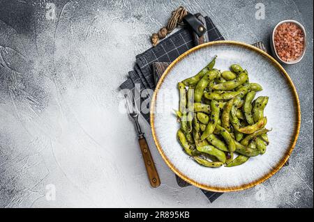 Scharfe gegrillte Edamame-Sojabohnen mit Meersalz auf einem Teller. Weißer Hintergrund. Draufsicht. Speicherplatz kopieren Stockfoto