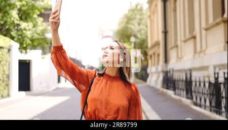 Schlechtes Signal und Anruf von einer asiatischen Frau, die in einer Stadt mit Internet, Verspätung oder Panne läuft. Schlecht, gute Verbindungen und weibliche Mitarbeiterin, die nach Empfang sucht Stockfoto