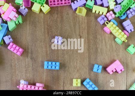 Schmutzige Legos auf Holzboden, Spielzeugkonzept für Kinder Stockfoto