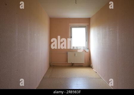 Beengtes, nicht renoviertes Zimmer, das als ausreichend Platz in einer typischen Ferienwohnung mit billigem Fußboden, freiliegenden Rohren und schlechter Insel gedacht war Stockfoto