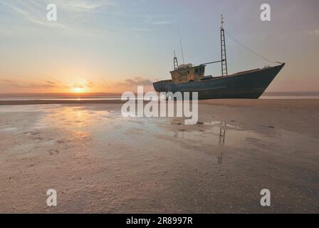 Inhambane, Mosambik - 12. 2009. Oktober: Foto eines stillgelegten Schiffes bei Ebbe, aufgenommen bei Sonnenuntergang. Stockfoto