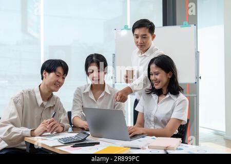 Lächelnde Kollegen versammeln sich in einem Brainstorming im Vorstand, um Finanzstatistiken zu besprechen. Glückliche Kollegen haben Spaß daran, bei zusammenzuarbeiten Stockfoto