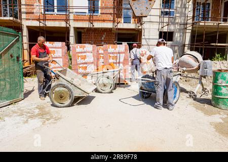 Zrenjanin, Vojvodina, Serbien – 11. Mai 2018: Arbeiter mit Schutzhandschuhen nimmt den Kranhaken von der Schubkarre voller Zellophan, Industriemüll. Stockfoto