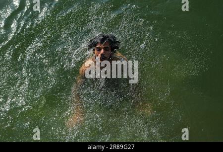 Srinagar, Indien. 19. Juni 2023. 19. Juni 2023, Srinagar Kaschmir, Indien : Ein Mann kühlt sich an einem heißen Sommertag in Srinagar im Wasser des Dal Lake ab. Am 19. Juni wurde in Srinagar eine Tagestemperatur von 31 Grad Celsius festgestellt, da die meteorologische Abteilung in den nächsten Tagen ein heißes und feuchtes Wetter in Kaschmir vorhersagt. Am 19. Juni 2023 in Srinagar Kashmir, Indien. (Foto: Firdous Nazir/Eyepix Group/Sipa USA) Kredit: SIPA USA/Alamy Live News Stockfoto