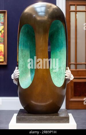 London, Großbritannien. 20. Juni 2023 Eine Technikerin mit „Elegy III“, 1966, von Barbara Hepworth (ca. 4,6 Mio. £) bei einer Vorschau auf die Highlights der Sommerverkäufe von Sotheby. Die Werke werden am 27. Juni bei den Abendauktionen Now und Modern & Contemporary in den Galerien der New Bond Street in Sotheby versteigert. Kredit: Stephen Chung / Alamy Live News Stockfoto