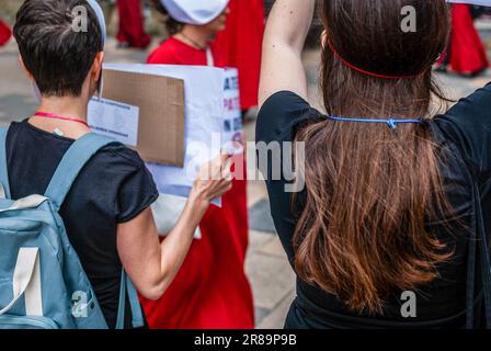 Radikale feministische Aktivisten, die in einem Kostüm aus der Serie „das Magazin“ gekleidet sind, nehmen an einer Demonstration gegen Leihmutterschaft Teil. Stockfoto