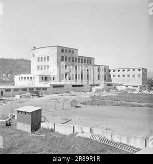 Actual 13-1950: Wieder eine neue FaktorenDie Industrie in Porsgrunn und der Umgebung vervielfacht sich eindeutig mit dem Anwachsen. Das letzte Unternehmen ist ein Ableger von Porsgrunds Porselænsfabrik, A/S Sanitærporselen, dem ersten und einzigen Unternehmen in Norwegen, das Toilettenschüsseln und Waschbecken herstellt. A/S Sanitærporselen übernahm nach dem Krieg ein solides Gebäude, das die Deutschen in Gang gesetzt hatten, um eine Kryolitfabrik zu errichten. Erst vor zwei Jahren begann man, das Gebäude als Porzellanfabrik nutzbar zu machen. Es war keine leichte Aufgabe. a. das Haus hatte seinen Anteil an der Bombardierung von Herøya erhalten, aber nach Erweiterungen und Veränderungen th Stockfoto