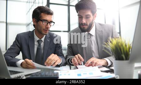 Kollegen sitzen an einem Tisch in einem modernen Büroflur Stockfoto