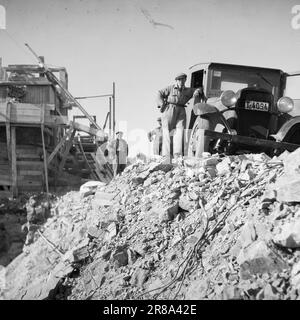 Tatsächlich 11 803-1-1947: Wiederaufbau in Kristiansund Kristiansund N. die auf Felsen und Bergen gebaute Stadt verschwand nach dem deutschen Bombenanschlag im Jahr 1940 in einem einzigen riesigen Feuer. Die Spuren sind fast gelöscht. Seit 7 Jahren leben sie in Baracken, so nah wie Hering in einem Fass. Noch sind nicht alle in die Stadt zurückgekehrt. Jetzt wird die Stadt wieder aufgebaut, aber es braucht Zeit. Christian Wonder Aksel Berge nennt seine Errungenschaften mit dem Lkw den „Tankfahrer“. Das Gummi hält nicht länger als 3-4 Monate! Foto: Per Bratland / Aktuell / NTB ***FOTO NICHT MIT BILD VERARBEITET* Stockfoto