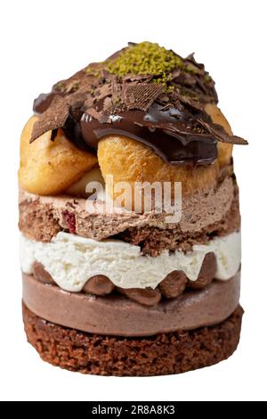 Mehrschichtiger Profiteroles-Kuchen isoliert auf weißem Hintergrund. Schlagsahne, Schokolade und Pistazienkuchen. Schließen. Stockfoto