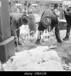 Aktuelle 13-7-1960: Wer hat geschossen? Ein Schuss kam aus dem Hotelzimmer im fünften Stock einer Farm in Richtung Karl-Johans-Tor. Im gleichen Moment brach ein Mann mittleren Alters auf einer Treppe die Straße runter zusammen, mit den Händen auf den Bauch gedrückt. Bevor er ohnmächtig wurde, beschwerte sich der 56-jährige Stationsvorarbeiter Nils Mathiesen über die Leute, die um ihn herum waren: Wer hat auf mich geschossen? Während die Ärzte um Mathiesen's Leben kämpften und die Leute sich beeilten, begannen die Ermittler mit ihrer gründlichen Arbeit. Nach sechs hektischen Stunden konnten sie die Frage beantworten. Der Schnee wurde mit Hilfe eines Flammenwerfers weggeschmolzen Stockfoto