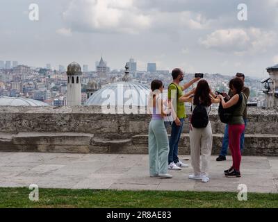 Touristen auf dem Gelände der Suleymaniye-Moschee genießen den Blick auf den Galata-Turm, Istanbul, Türkei Stockfoto