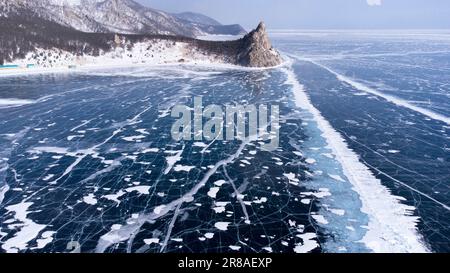 Ein ruhiger See inmitten einer schneebedeckten Bergkette mit schmelzendem Eis an der Oberfläche Stockfoto