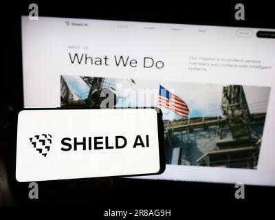 Person, die ein Smartphone mit dem Logo des US-amerikanischen Luft- und Raumfahrtunternehmens Shield AI auf dem Bildschirm vor der Website hält. Konzentrieren Sie sich auf das Display des Telefons. Stockfoto