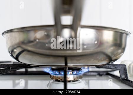 Edelstahlpfanne auf Gasherd Stockfoto