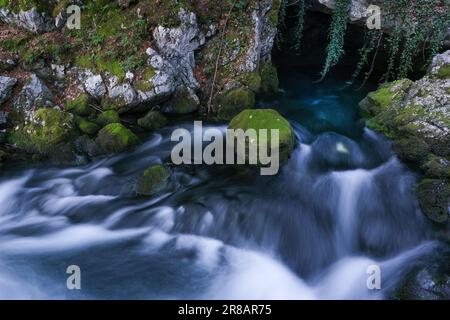 Ein kleiner Fluss, der aus einer Höhle am Gollinger Wasserfall fließt (Zeitraffer des fließenden Wassers) Stockfoto