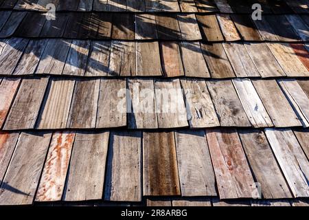 Hintergrund für alte Holzdachfliesen. Holzhintergrund. Klassisch. Design mit Holzdach. Altes braunes Schindeldach Blick auf die Holzeisen. Wand Stockfoto