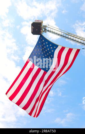 Pater's Day Auto Show - Hyannis, Massachusetts, Cape Cod - USA. Die amerikanische Flagge fliegt von einer Leiter des Feuerwehrturms von Hyannis Stockfoto