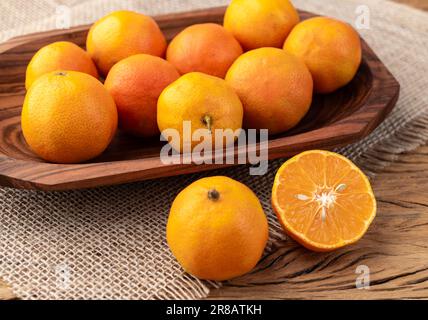 Cravo oder RosenZitronen in einer Schüssel über einem Holztisch. Stockfoto