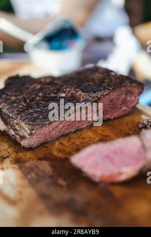 Ein saftiges Steak auf einem Schneidebrett, fertig zum Schneiden und Servieren Stockfoto