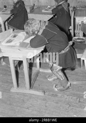 Aktuelle 3-1950: Natürliche Kinder in Zwangsjacken. Schulkinder in Karasjok in einem Internat. Für die Bergbewohner ist es völlig unnatürlich, mit dem Rücken auf einem Stuhl zu sitzen und die Füße auf dem Boden zu haben. Wenn die Sami-Kinder zur Schule kommen, sitzen sie gerne mit gekreuzten Beinen auf dem Stuhl. Das ist natürlich für sie. Aber solche primitiven Gewohnheiten können natürlich in unseren Schulen nicht akzeptiert werden. Foto: Sverre A. Børretzen / Aktuell / NTB *** FOTO NICHT IMAGE PROCESSED*** Stockfoto