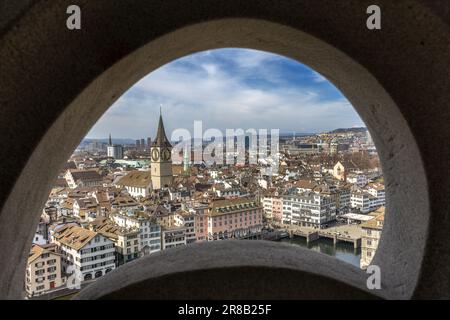 Zürich, Schweiz - März 26. 2021: Züricher Innenstadt und St. Die Peter-Kirche blickte durch einen Wandrahmen auf der Spitze der Kirche Grossmunster Stockfoto