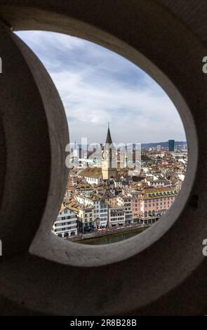 Zürich, Schweiz - März 26. 2021: Züricher Innenstadt und St. Die Peter-Kirche blickte durch einen Wandrahmen auf der Spitze der Kirche Grossmunster Stockfoto