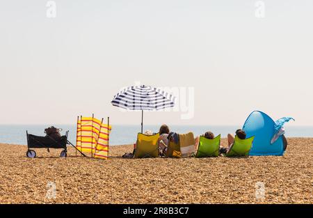 Touristen entspannen sich und genießen den Meerblick am Aldeburgh Beach an einem hellen, sonnigen Tag. Suffolk, Großbritannien Stockfoto